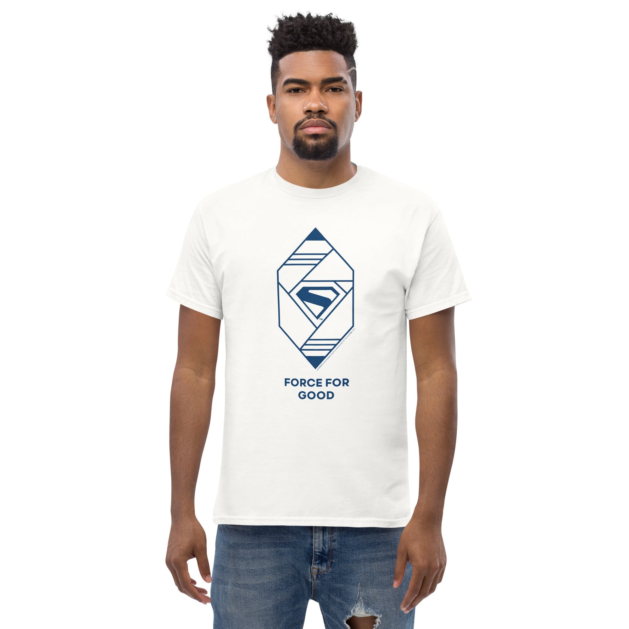 Homme posant avec un t-shirt blanc Force for Good, emblème Superman 2025 en bleu, look casual inspiré des super-héros DC Comics.