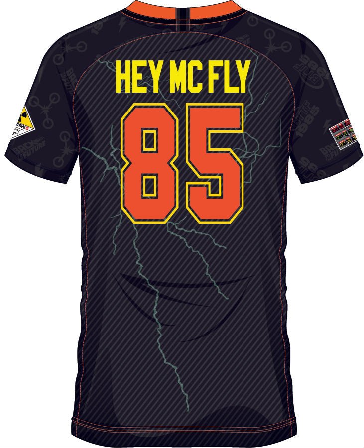 Dos du maillot 'HEY MCFLY 85' Retour vers le Futur avec numéro 85 en orange et jaune, éclairs stylisés et lettrage rétro pour fans de cinéma.