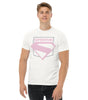 Homme portant un t-shirt blanc Superman avec emblème rose pastel, style inspiré du film Superman 2025, mode urbaine pour fans de DC Comics.