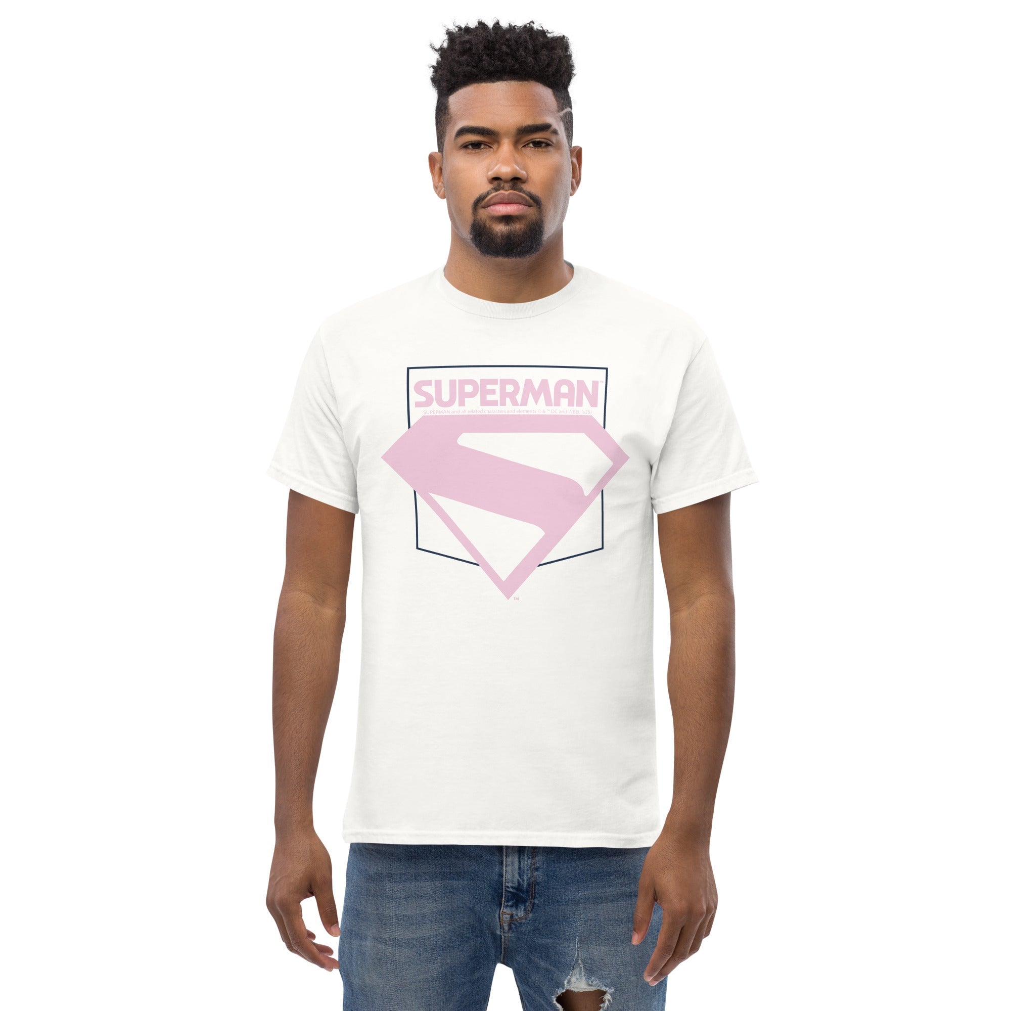 Homme en t-shirt blanc avec logo Superman rose pastel, design du nouveau film Superman 2025, look moderne pour amateurs de super-héros.
