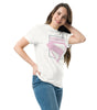 Femme souriante en t-shirt Superman blanc avec logo rose pastel, design du film 2025, idéal pour un look geek chic et décontracté.