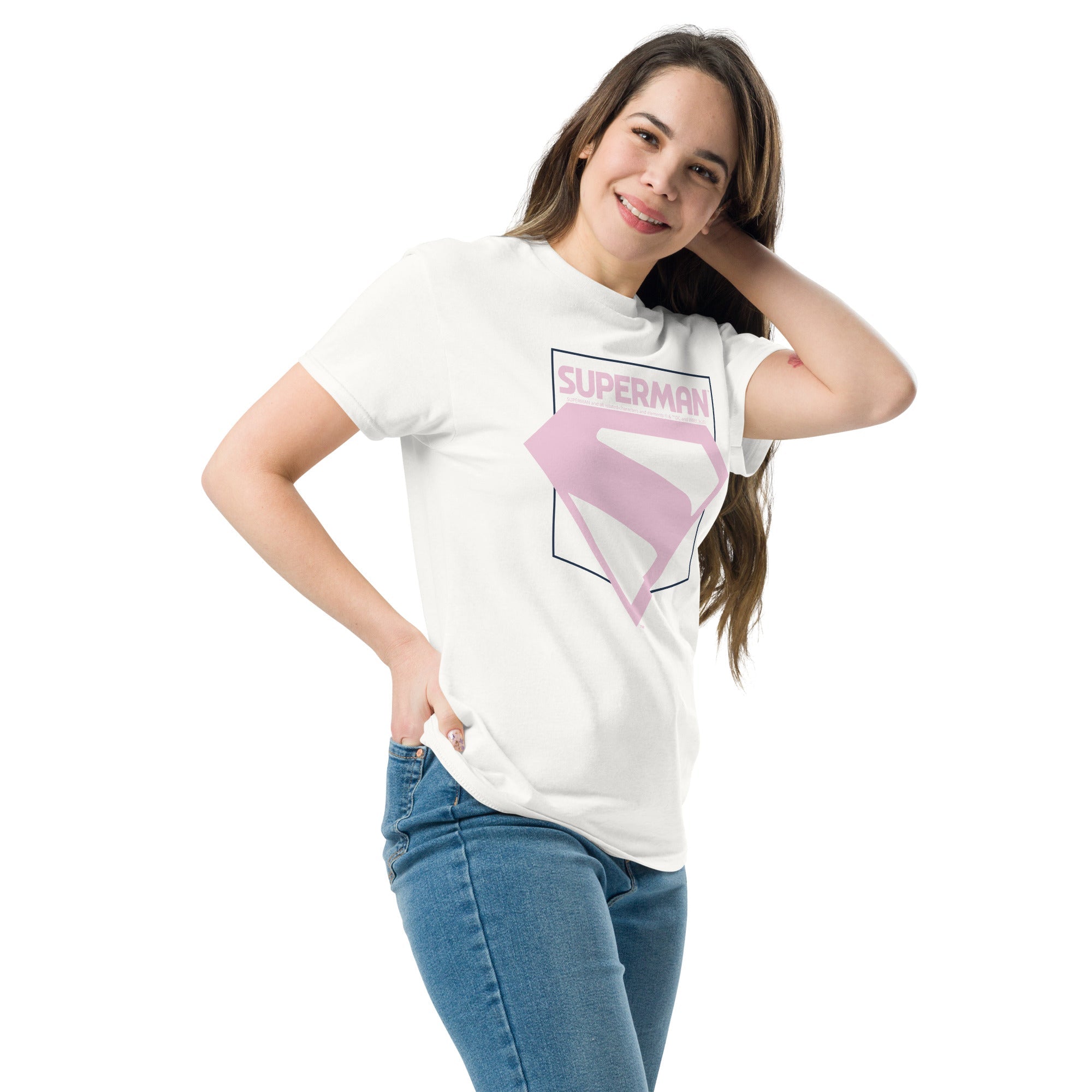 Femme souriante en t-shirt Superman blanc avec logo rose pastel, design du film 2025, idéal pour un look geek chic et décontracté.