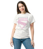 Femme portant un t-shirt blanc avec emblème Superman rose pastel, style inspiré du film Superman 2025, mode décontractée pour fans DC Comics.