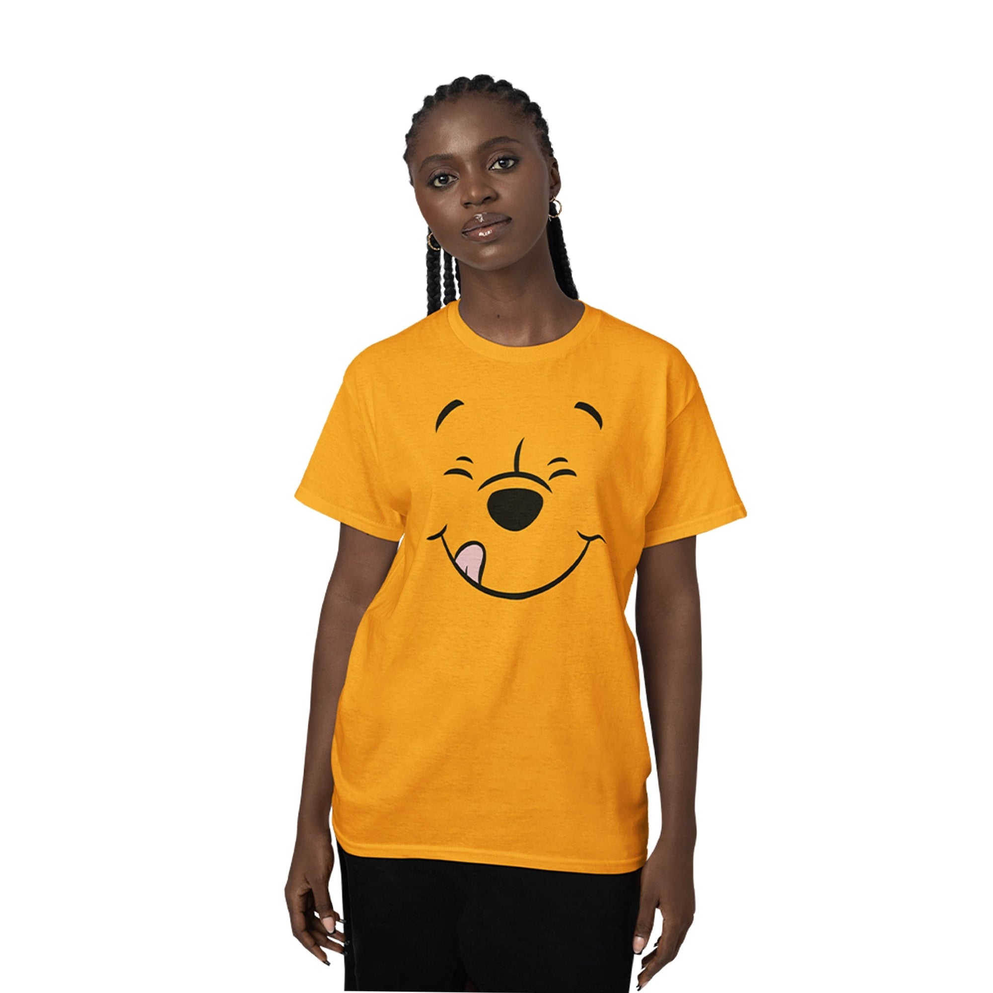 T-shirt Disney - WINNIE SMILE orange porté par une femme, avec un grand motif du visage souriant de Winnie l'ourson sur le devant. T-shirt classique pour homme ou femme, parfait pour les fans de Disney.